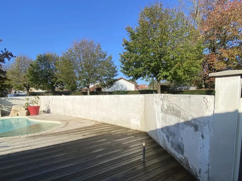 Mur de clôture autour d'une piscine avant peinture, traces et salissures