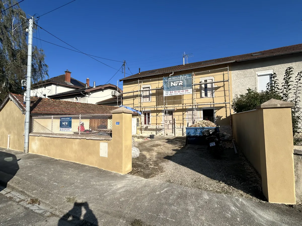Ferme en pisé sous échafaudage, corps d'enduit posé, banderole NFR