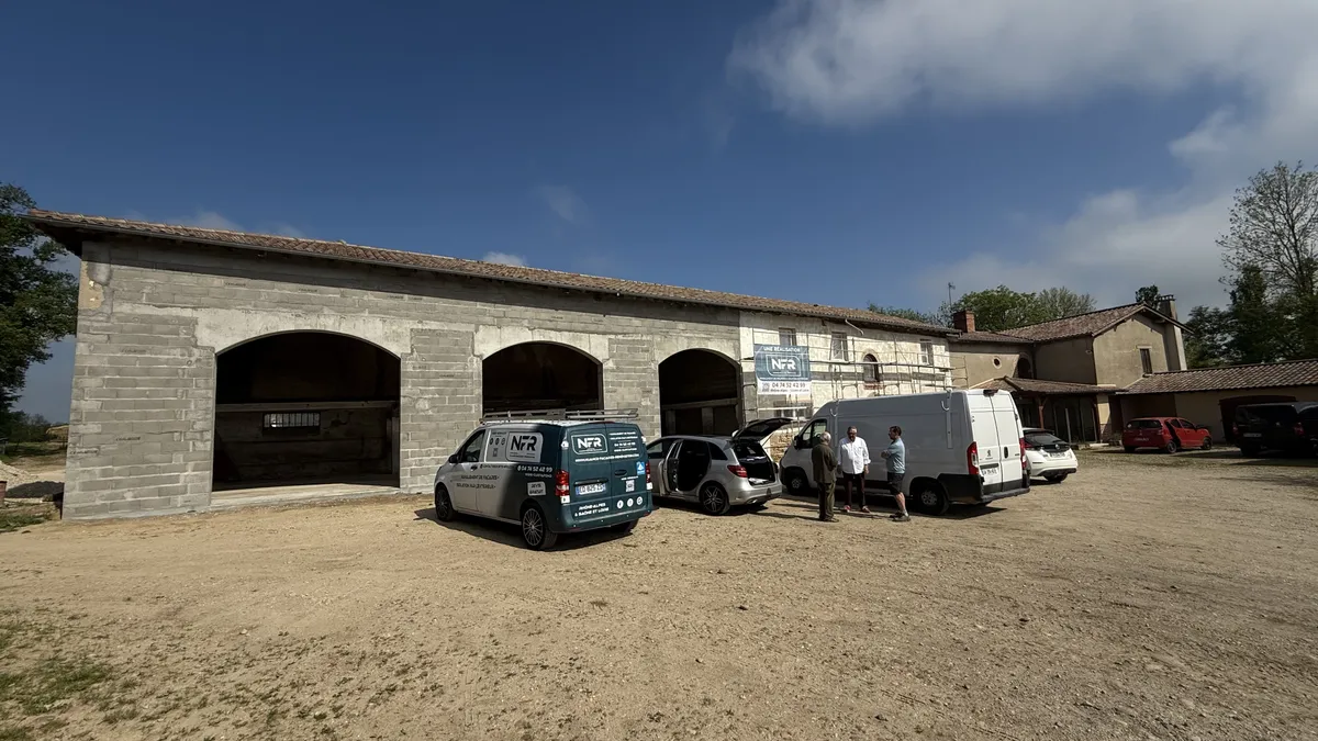 Ferme en pisé au démarrage du chantier, camion et équipe NFR dans la cour