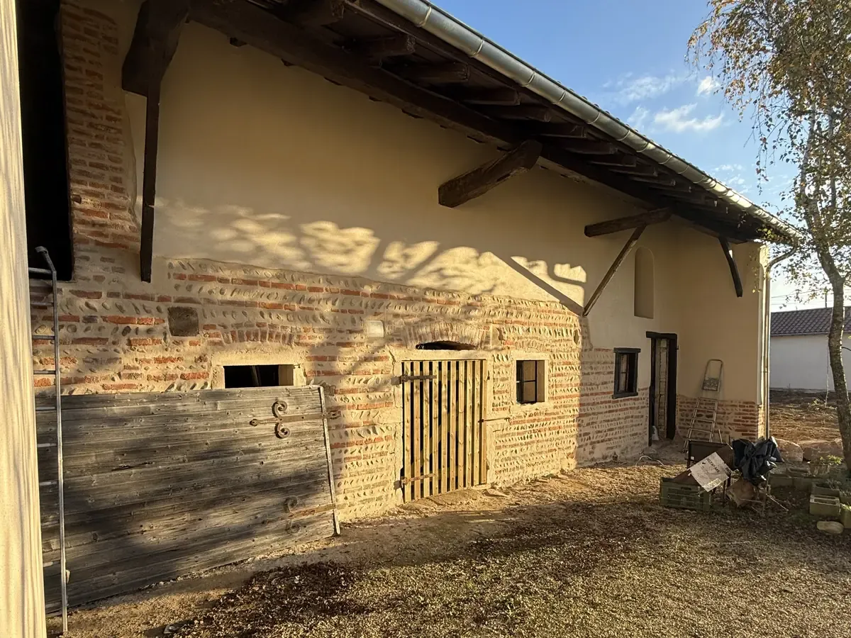 Le même mur de grange enduit à la chaux par NFR, soubassement en brique conservé