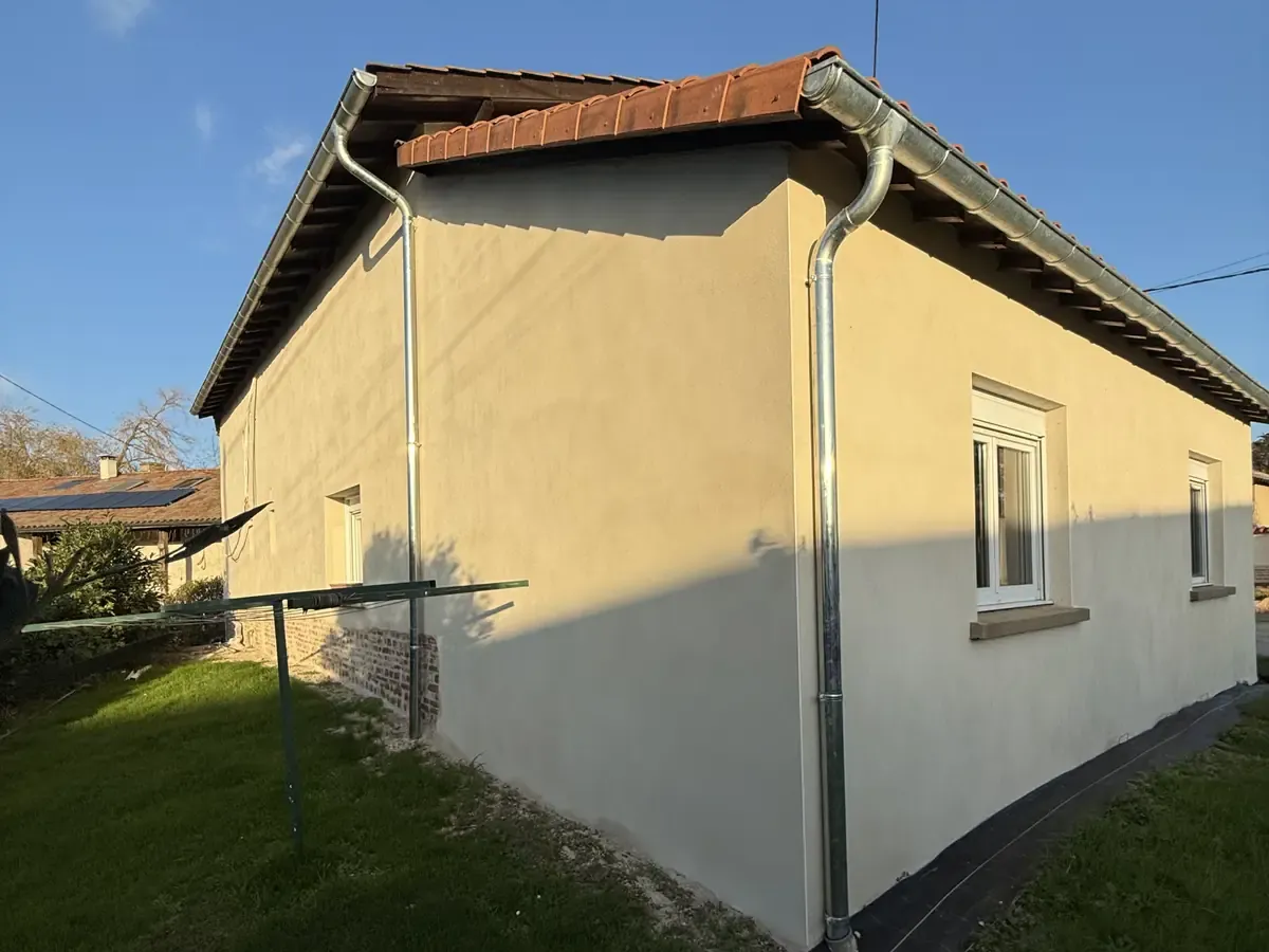 Pignon de grange en pisé enduit, gouttières et descentes neuves