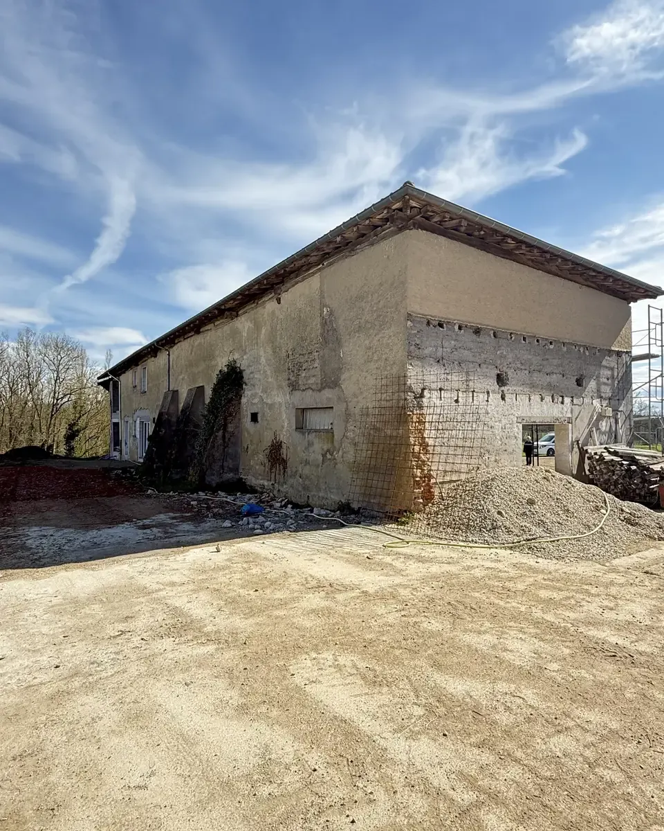 Avant : mur en pisé à nu, taché par l'humidité